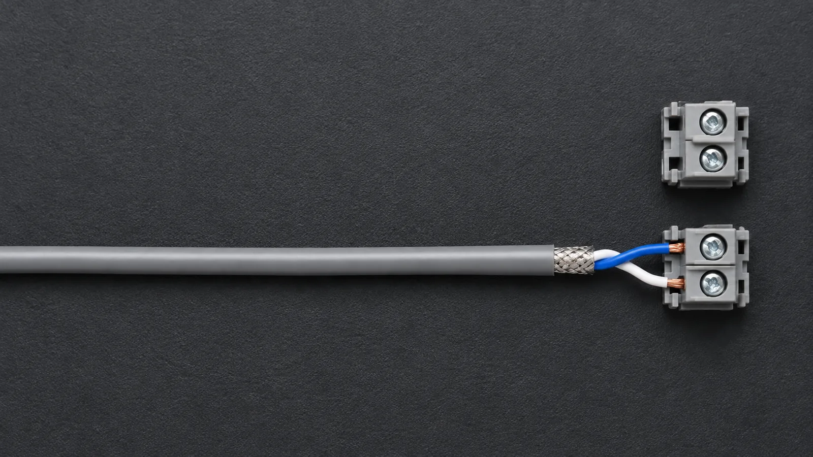 Ilustrasi AI: kabel twisted pair berpelindung dengan dua konduktor terjepit pada blok terminal sekrup, tampak atas